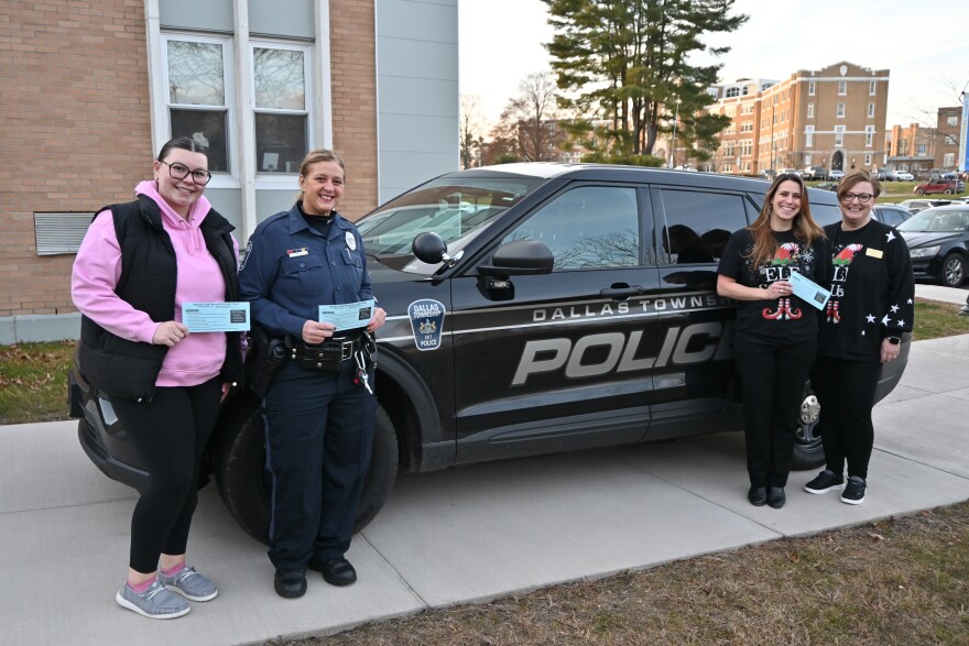 Carlie Coombs, presiden Klub Kesadaran Autisme Cougars di Misericordia; Petugas Gina Kotowski dari Departemen Kepolisian Kotapraja Dallas; Orley Templeton, profesor dan master direktur program PL; dan Lori Charney, profesor madya dan ketua Departemen PL serta penasihat Cougars untuk Klub Kesadaran Autisme, berpose dengan amplop biru. Cougars for Autism Awareness Club milik Misericordia bermitra dengan Dallas Twp. Departemen Kepolisian untuk mendistribusikan amplop.