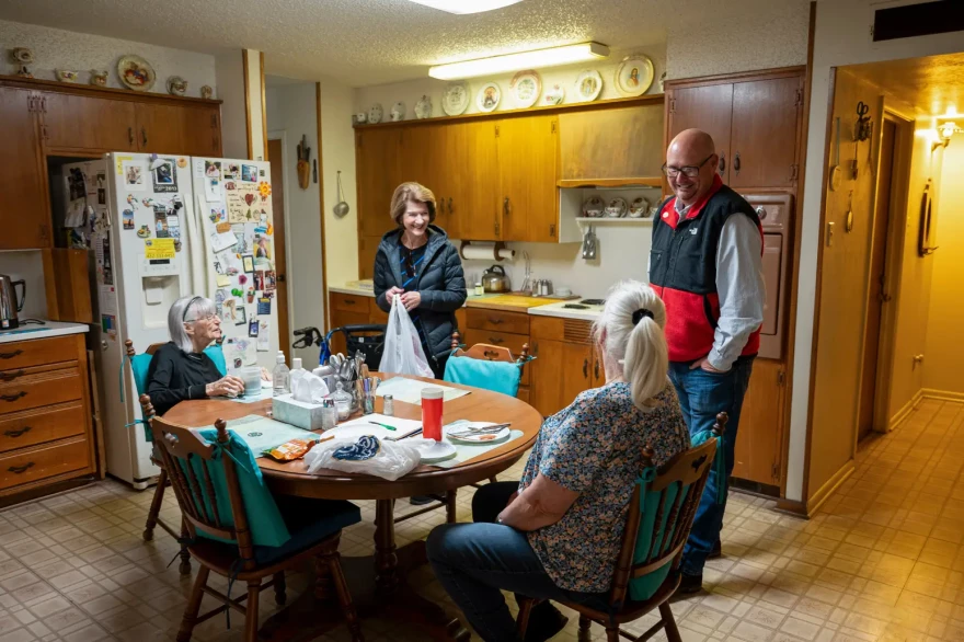 Craig Stoker, far right, and his mother Carole Stoker, center left, deliver a meal to Rosetta Cuba as part of Meals on Wheels on Dec. 3.