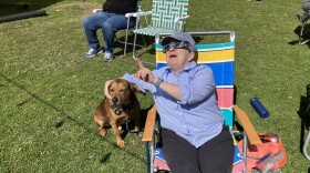 Anne Rogers views the solar eclipse with her dog, Odie, in Florence, Massachusetts, on April 8, 2024.