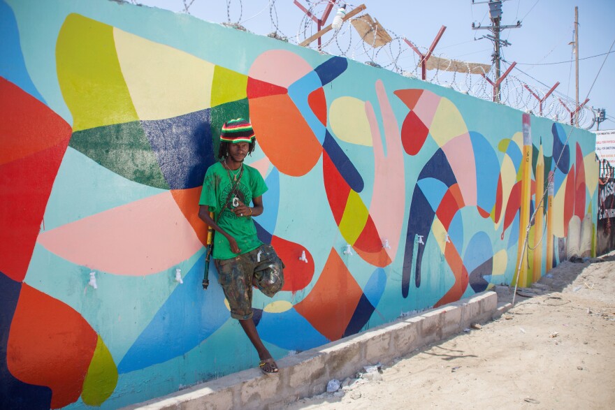 Guinean artist Kingston Sylla and Nanook spent days painting in the details of an abstract mural that brightens up the concrete wall in front of the school. It was his idea to add pencils to the design.