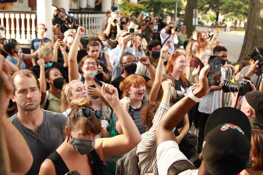 People cheer as they watch the removal of the Lee statue, the largest Confederate monument in Richmond.