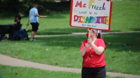 Event organizer and teacher Chelsea Egli holds a sign saying "Ms. Frizzle would be so disappointed" at a rally Saturday, August 1, 2020. 