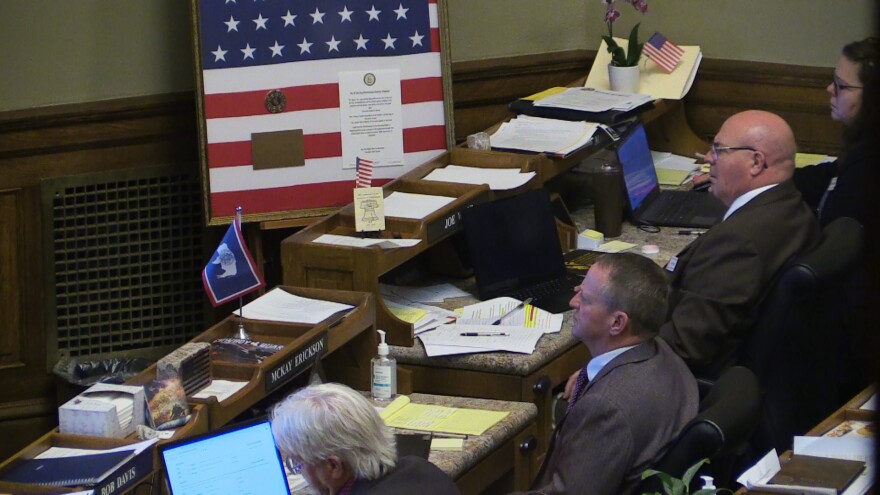 Representatives in the Wyoming House near a flag with 44 Stars
