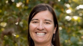 Headshot of a woman in a black and white shirt