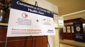 A sign tells visitors at St. David's Medical Center to alert staff if they've traveled to a region with cases of COVID-19 and have certain respiratory symptoms. 