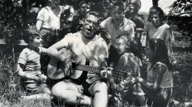 A camp counselor plays the guitar and leads children in singing at Camp Butwin in Minnesota in 1962.