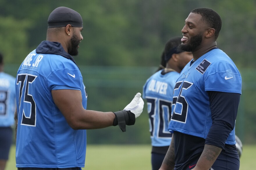 Tennessee Titans offensive tackles Dan Moore Jr., left, and JC Latham right, talk after an NFL football practice Tuesday, June 3, 2025, in Nashville, Tenn. (AP Photo/George Walker IV)