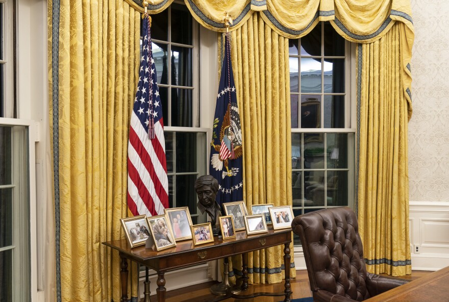 A bust of labor organizer and civil rights leader César Chávez sits on a table with Biden family photographs.