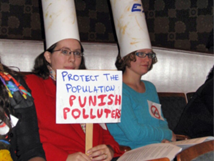 Exide lead plant critics wear smokestacks as hats during a Frisco council meeting Tuesday.