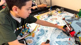 Fourth grader Sergio Preciado shows off a Lego shipwreck he helped build and code with his FIRST Lego League team, called the Dino Nuggys. The program is mostly grant funded through the Washington Office of Superintendent of Public Instruction. (Credit: Courtney Flatt / NWPB)
