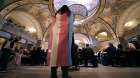 Glenda Starke wears a transgender flag as a counter protest during a rally in favor of a ban on gender-affirming health care legislation, March 20, 2023, at the Missouri Statehouse in Jefferson City, Mo. A judge's ruling striking down Arkansas' first-in-the-nation ban on gender-affirming care for minors, on June 20, is offering hope to transgender people, families and providers after a historic wave of restrictions on trans people's lives sailed through Republican statehouses this year.