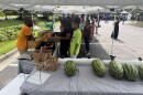 Thelonious Cook chats with customers at his produce stand outside E. Palmer Supermarket during the Mid-Atlantic Black Farmers Market in Berkley. The market runs on the first and third Saturday of each month through November.