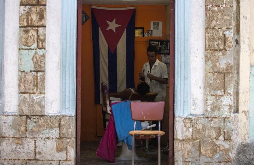 A Cuban barber shaves a customer at his privately owned business in Havana.