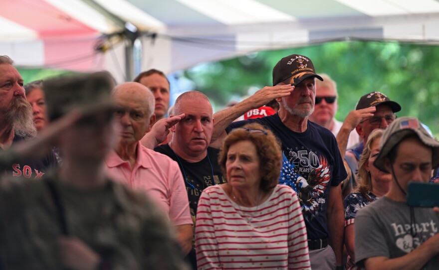 Members of the United States Armed Services stand at attention during the presentation of the flag.