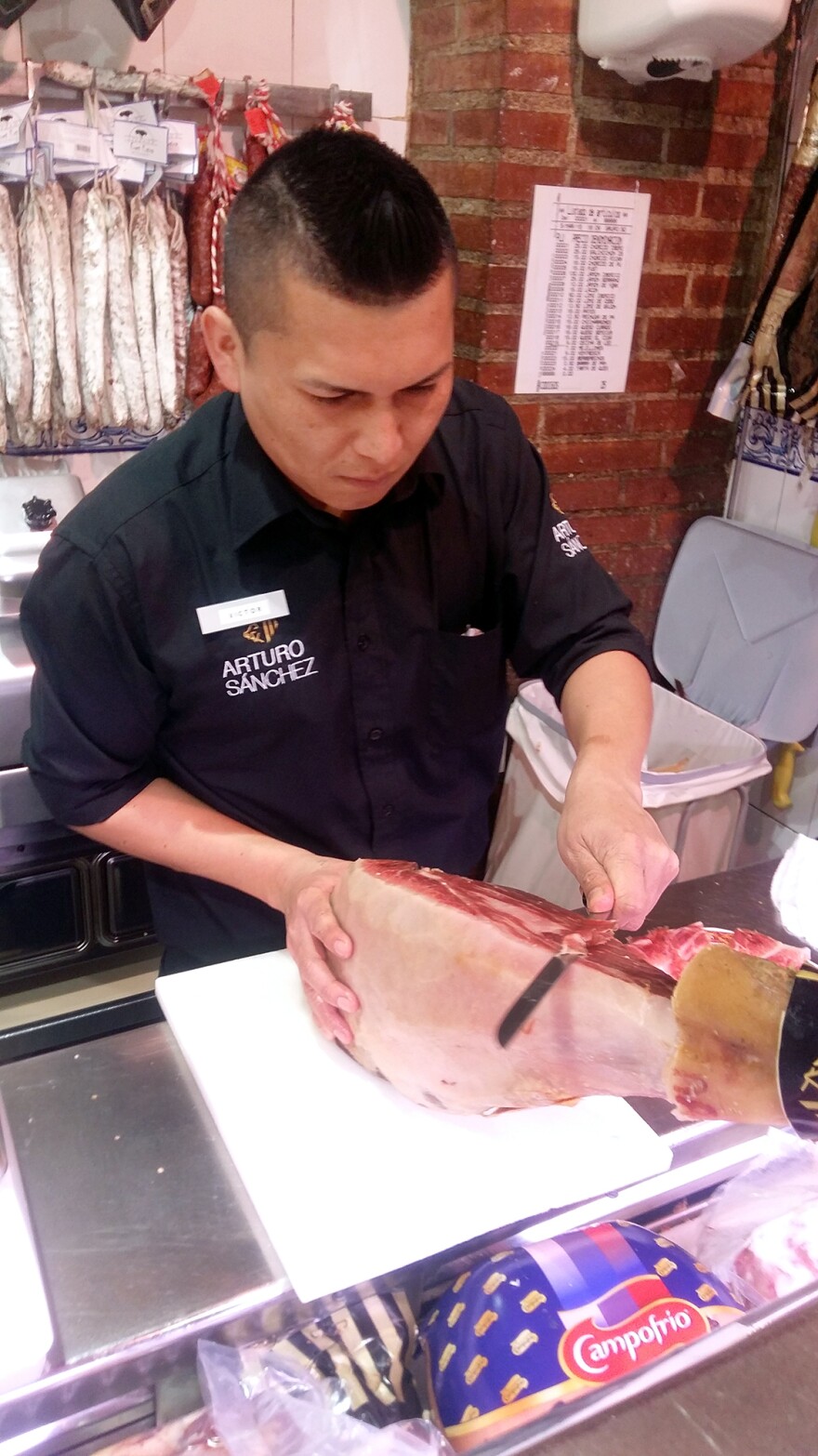 A ham cutter demonstrates how to carefully slice Spanish <em>jamón</em> at the Don Jamón tapas bar on Madrid's Gran Vía.