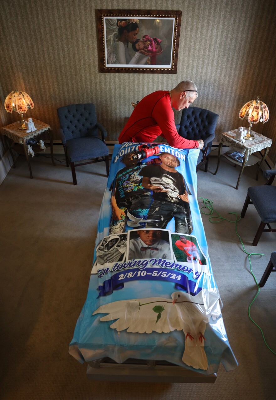 Richard Collinge wraps a casket for a family who's son died the day before the funeral at Angel Hills Funeral Chapel in Rochester.