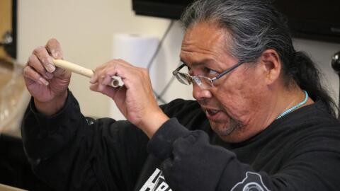 GRAMMY-nominated musician Aaron White, of Diné and Northern Ute ancestry, inspects a reed of river cane during a traditional flute-making workshop in January.