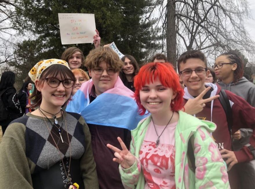 Students Madeleine Van Amburgh, Owen Taggi, Ella Brock and others posed for a photo during an protest against anti-LGBTQ legislation.