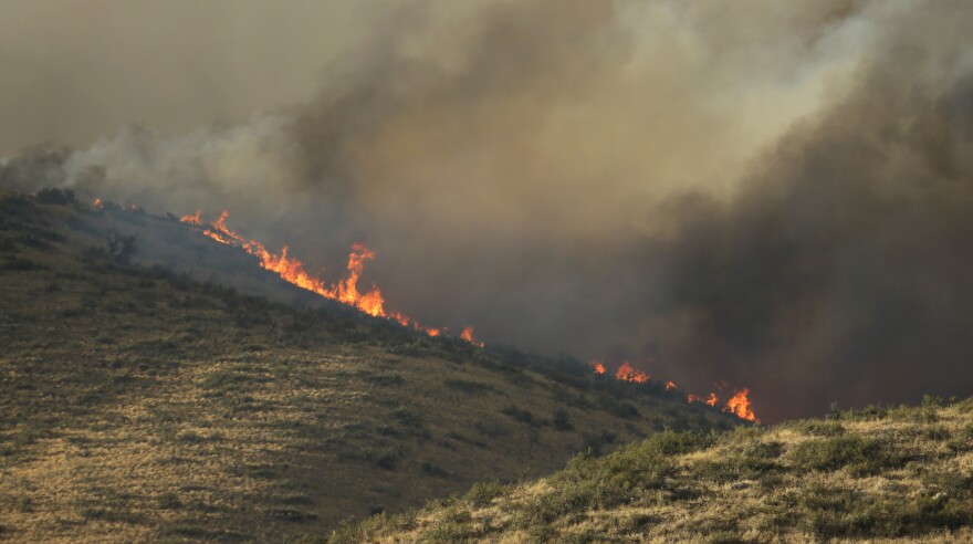 Flames and smoke rise on a hillside above Twisp River Road near Twisp, Wash., Wednesday, Aug. 19, 2015.