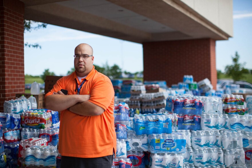 Kyle Duncan, the business administrator at the First Baptist Church, stands by the donation staging area where people have dropped off goods.