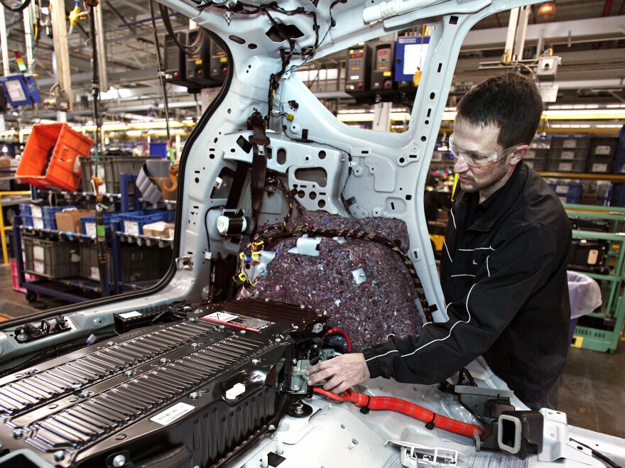 Better than expected: Economic growth was higher in the third quarter than first thought. Here, a worker at a Ford plant in Michigan plugs a batter into a Ford C-MAX plug-in hybrid vehicle.