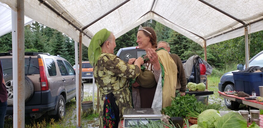 Zuba Dorvell (left) places a crown and cape on Jennifer Castellani at the Zucchini Fest at the Homer Farmers Market on Saturday, Aug. 26 in Homer. Castellani is the first queen crowned since the last festival in 2019.