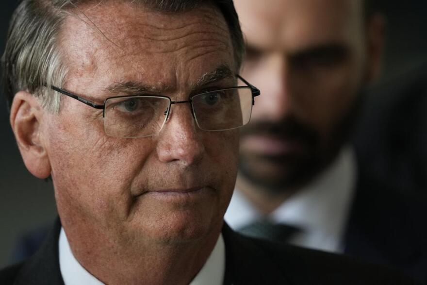 Brazilian President Jair Bolsonaro speaking at the Alvorada presidential palace in Brasilia on Tuesday, as his congressman son Eduardo Bolsonaro stands behind him.