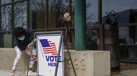 Poll worker Pranee Sheskey puts up a sign outside the Warner Park Community Recreation Center for the first day of early voting Tuesday, March 21, 2023, in Madison, Wis.