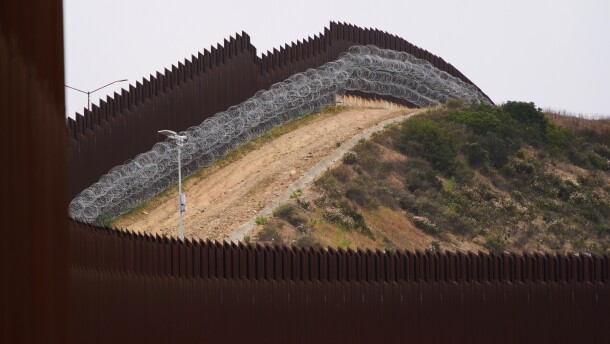 FILE - Concertina wire lines the interior of a border wall separating Tijuana, Mexico, from the United States, June 4, 2025, in San Diego.