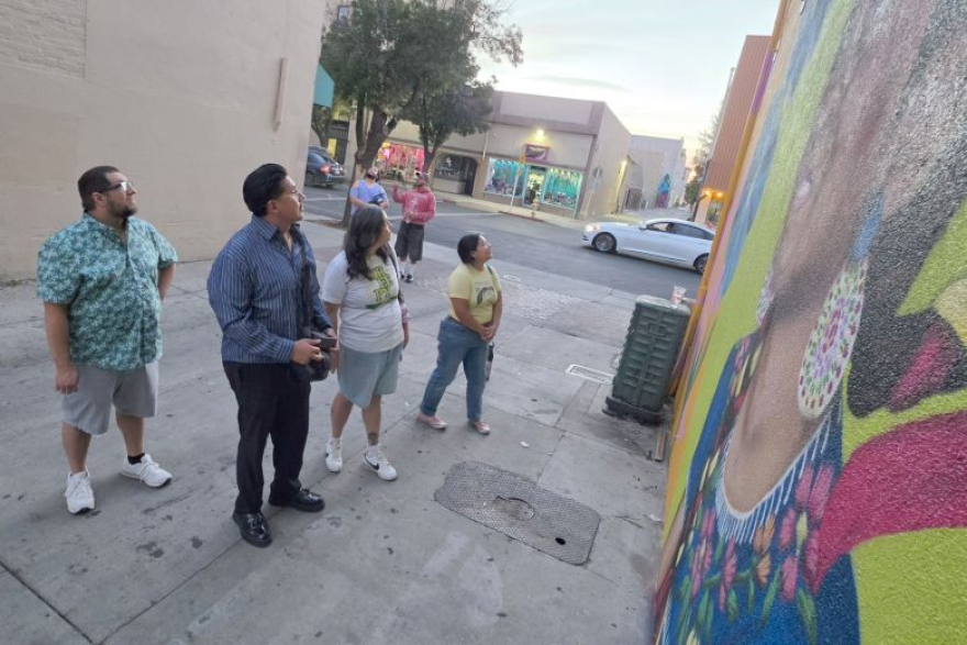 Local artists Eddie Rodriguez (far left), Earvin Mendoza (left), Patricia Pratt (center), and Jazz Shane-Diaz (right) look at Pratt’s mural, created during the Merced Arts Festival.