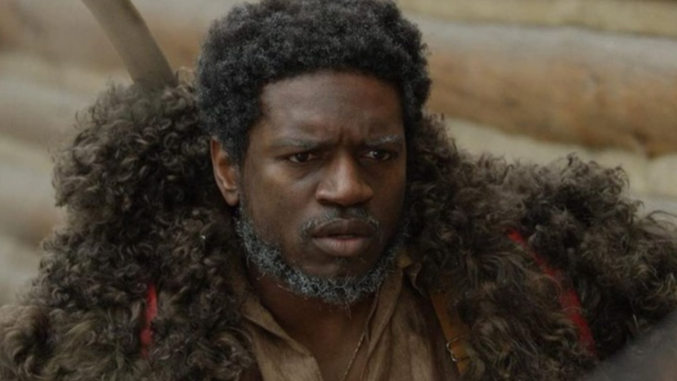 Close-up of a Black man wearing some sort of fur coat.