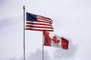In this photo taken Sunday, May 17, 2020, U.S. and Canadian flags fly atop the Peace Arch at Peace Arch Historical State Park on the border with Canada. (Elaine Thompson/AP)