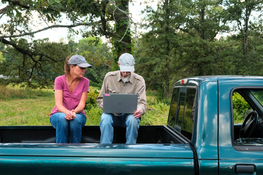 Kim Erndt-Pitcher and Marty Kemper review leaf sampling data near the state record post oak, one of Prairie Rivers Network’s monitoring sites. (credit: Christian Elliott)