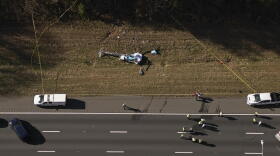 In this image take with a drone, emergency personnel work at the scene of a helicopter crash on the side of Interstate 77 South in Charlotte, N.C., Tuesday, Nov. 22, 2022. Authorities said two people died.