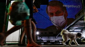 An image of Brazil's President Jair Bolsonaro wearing a protective face mask and the question, "Negative?" is projected on the wall of a building as a protest against the president regarding his handling of the coronavirus COVID-19 outbreak, in Sao Paulo, Brazil.