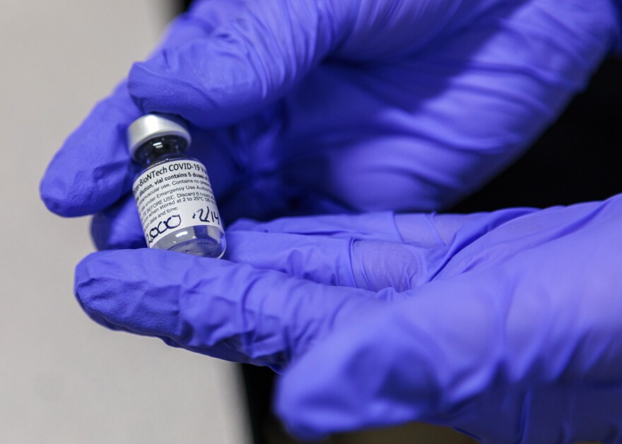 A health care worker at Truman Medical Center displays a vial of the Pfizer-BioNTech COVID-19 vaccine that was shipped to Kansas City yesterday and was used to inoculate staff there.
