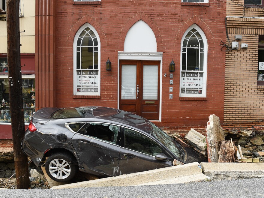 Flooding along Main Street in Ellicott City upended cars, destroyed buildings and killed at least two people. Here, a car sits crushed under the rubble of a sidewalk downtown.
