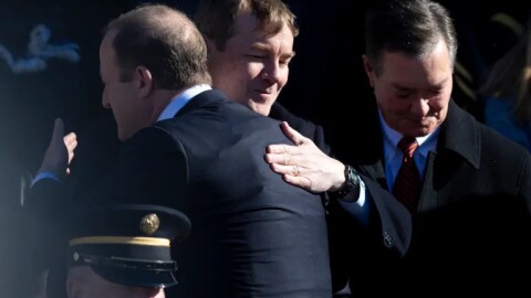 Gov. Jared Polis, possibly wearing a bullet proof vest, greets U.S. Sen. Michael Bennet during the swearing-in ceremony, Tuesday, Jan. 10, 2023, at the Colorado State Capitol in Denver.
