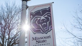 The sun shining on a Missouri State University Bear head logo banner.