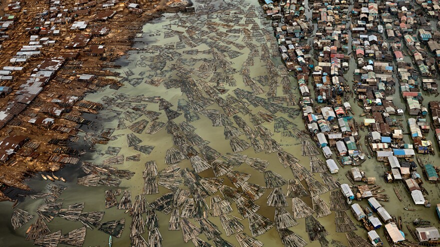 This aerial photo depicts the sawmills of Lagos, Nigeria. The timber from the country's rainforests, some of the most heavily deforested in the world, are processed in this coastal city, polluting the lagoons.