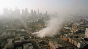 Smoke rises from a shopping center burned by rioters early Thursday morning on April 30, 1992, as the Los Angeles skyline is partially obscured by smoke. (Paul Sakuma/AP)