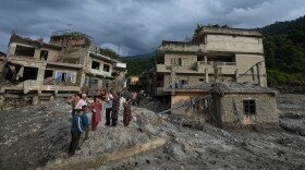 Residents and others look at damaged structures after flash flooding in the Devighat area of the Nuwakot district in Nepal, Friday, Aug. 28, 2026. (AP Photo/Rajesh Kumar Singh)