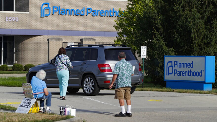 FILE - Abortion protesters attempt to hand out literature as they stand in the driveway of a Planned Parenthood clinic in Indianapolis, Aug. 16, 2019. Hospitals and abortion clinics in Indiana are preparing for the state's abortion ban to go into effect on Sept. 15, 2022.