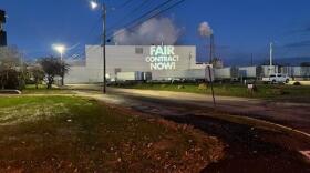 A "Fair Contract Now!" light shines on the Woodland Pulp mill in Baileyville, Maine on the evening of Nov. 17, 2022.