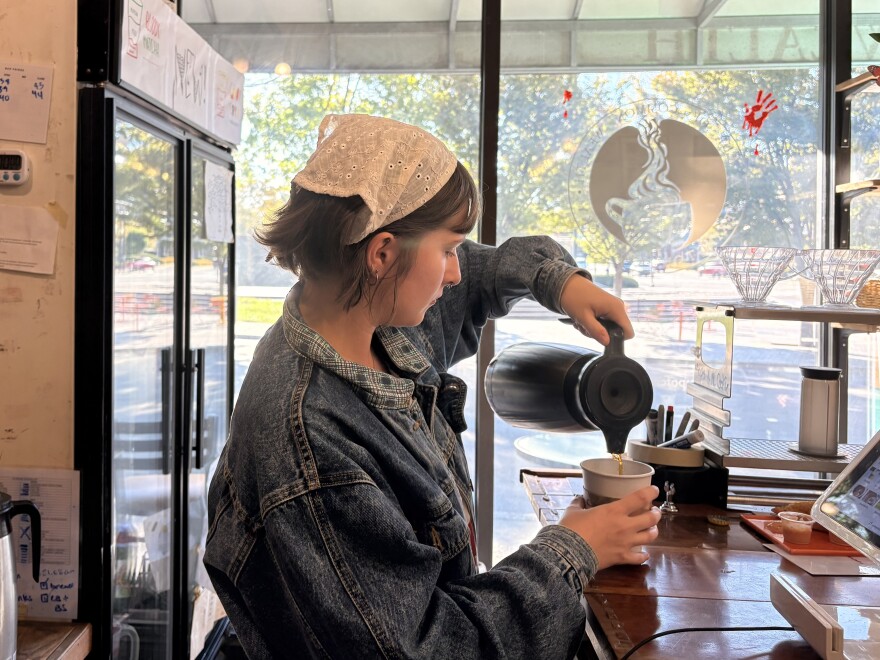 Kaitlyn Cooper, a barista at A Cup of Common Wealth, pours a coffee behind the counter. A Cup of Common Wealth is directly across the street from Thoroughbred Park and Northeastern Park Playground.