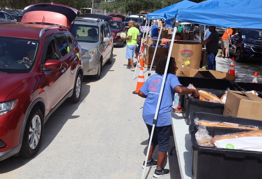 Hundreds of cars passed through the food distribution lines on either side of a row of tents as volunteers placed food in the trunk, bed or back of each vehicle.