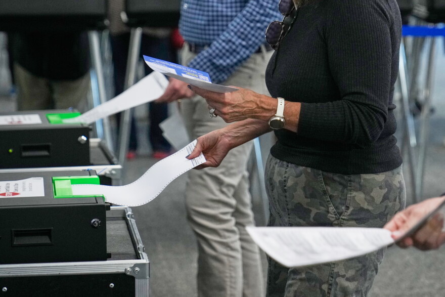 Voters enter their ballots into scanners at early in-person voting in Cleveland, Wednesday, Oct. 7, 2026.