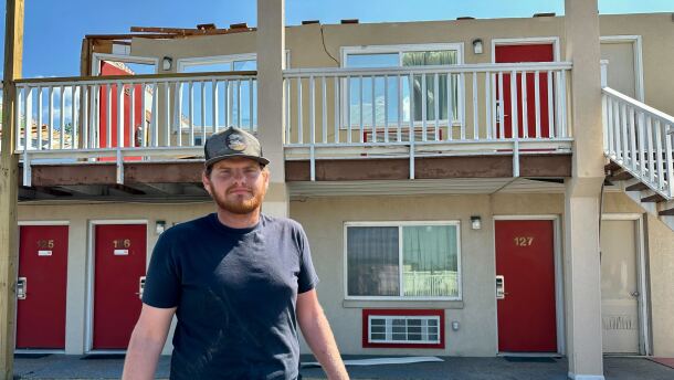 Kolton George stands in front of the Knights Inn Motel in Ottawa. A Monday night tornado blew out the hotel’s roof, windows and parts of its walls.
