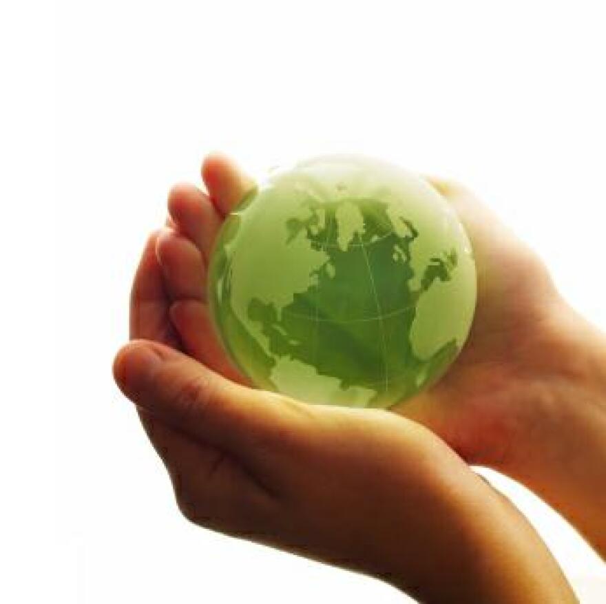 A green globe held in cupped palms.