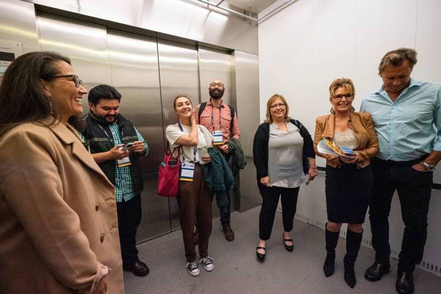 Mary Peltola, left, rides an elevator after a U.S. House candidate forum with Sarah Palin, who was escorted by Ron Duguay, at the Alaska Oil and Gas Association conference on Wednesday, Aug. 31, 2022 at the Dena'ina Civic and Convention Center in Anchorage. Results showing Peltola as the winner were announced shortly after the forum.